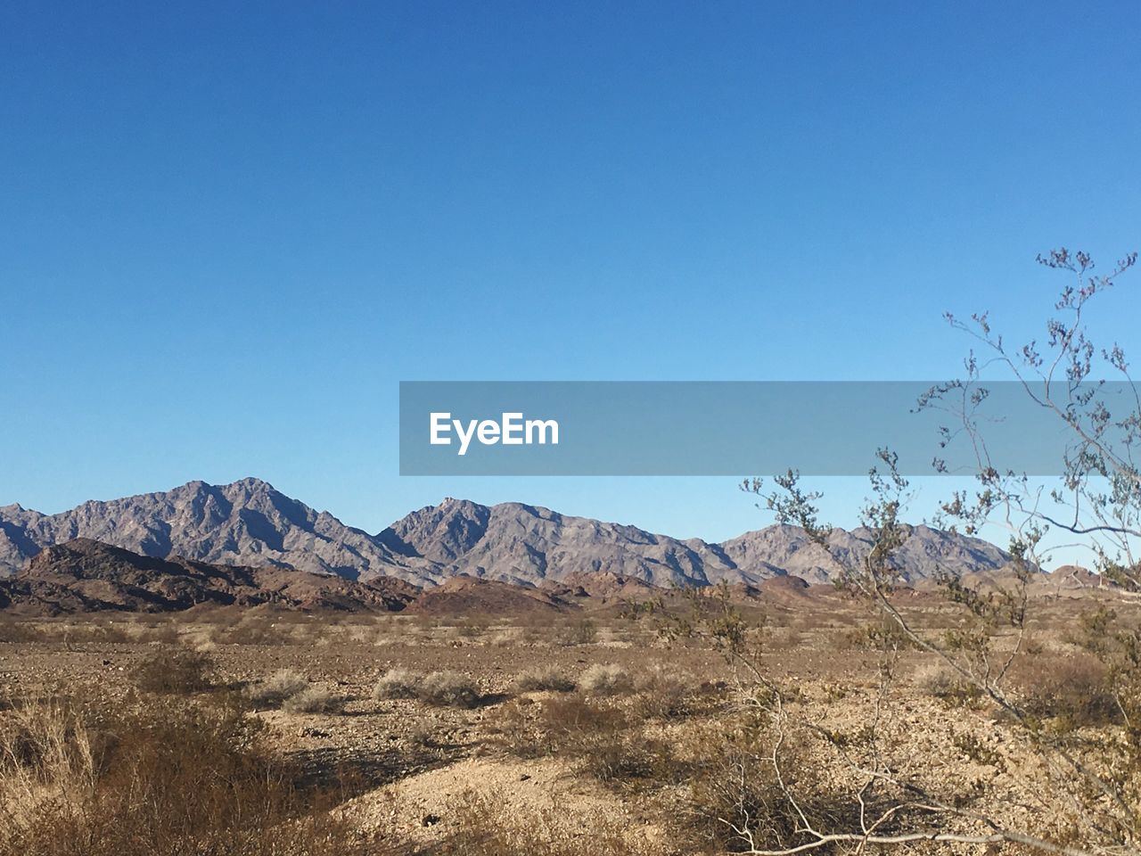 Scenic view of mountains against clear blue sky