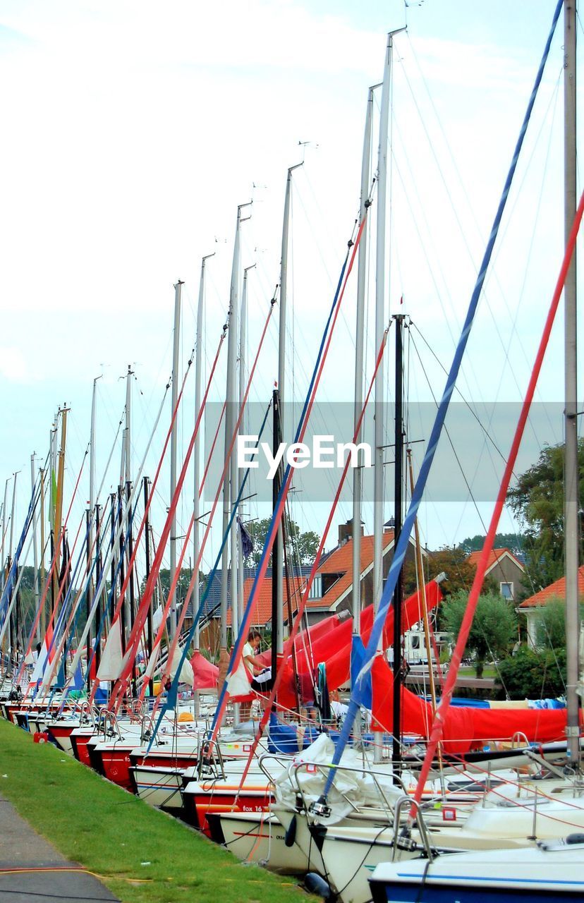 Moored boats in row against the sky