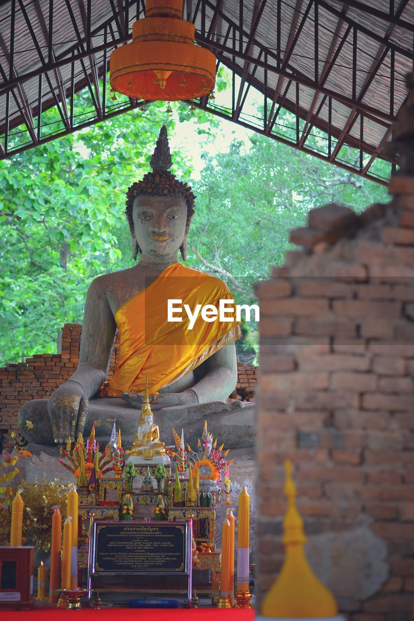 STATUE OF BUDDHA OUTSIDE BUILDING AGAINST TEMPLE