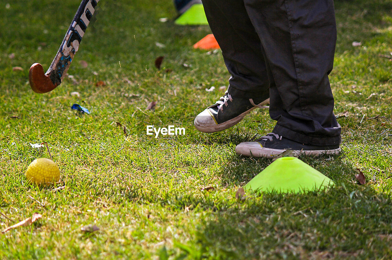 Low section of man playing hockey on field