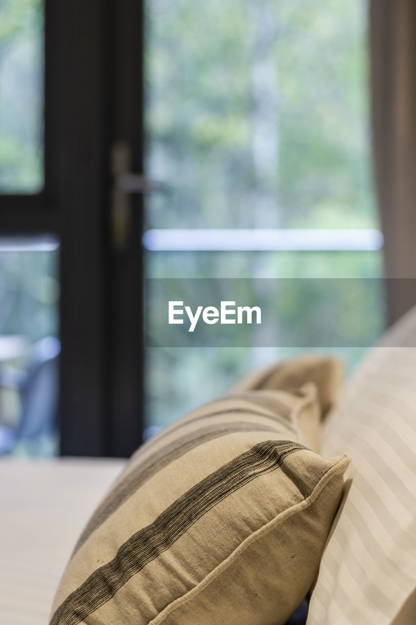 Close-up of glass window over bed at home