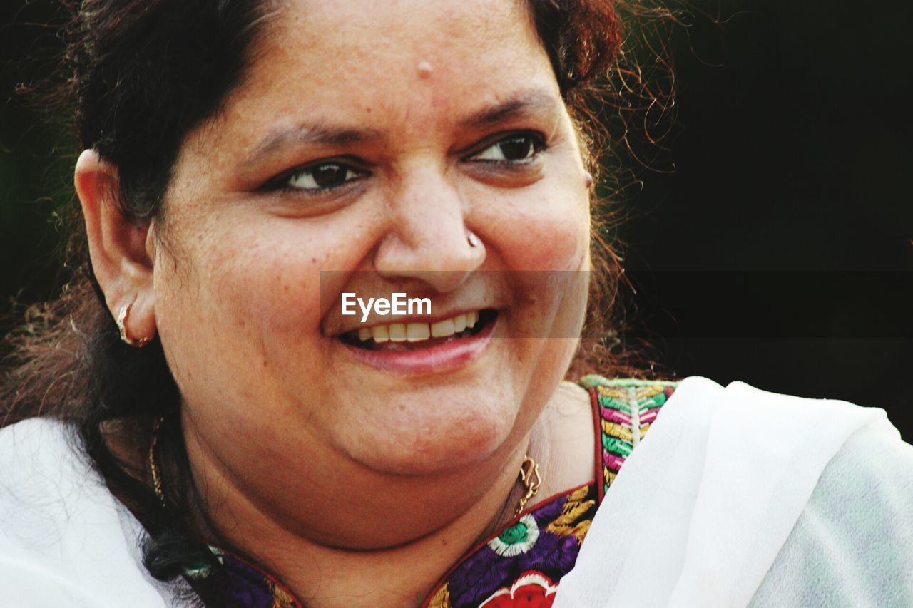 Close-up of smiling woman looking away