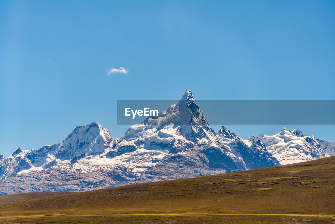 Scenic view of snowcapped mountain against blue sky