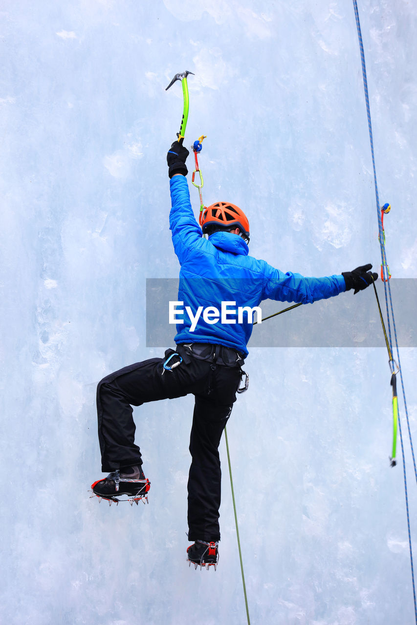 Rear view of man ice climbing