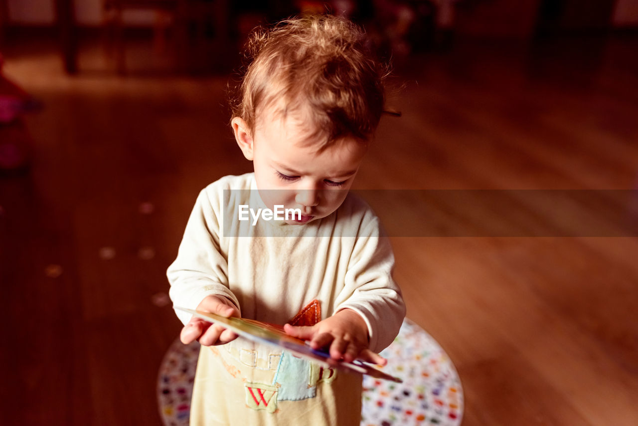 Boy looking away while sitting on floor