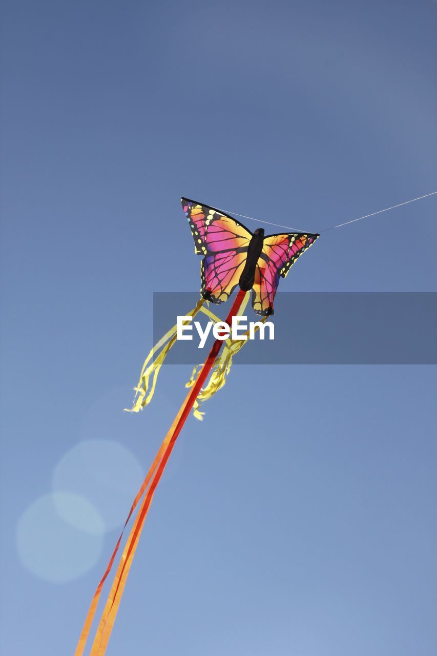 LOW ANGLE VIEW OF KITES FLYING AGAINST SKY