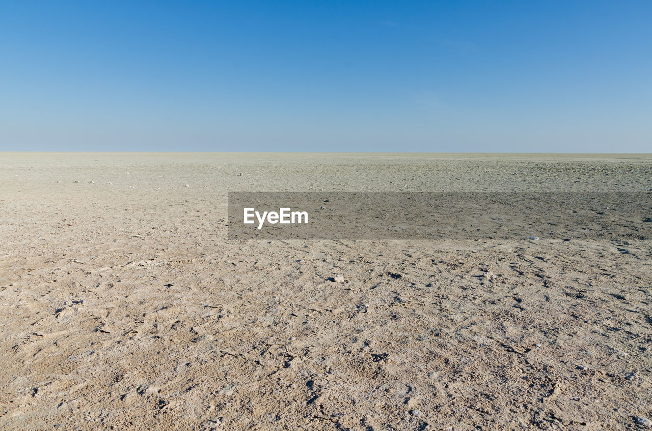 Scenic view of beach against clear blue sky