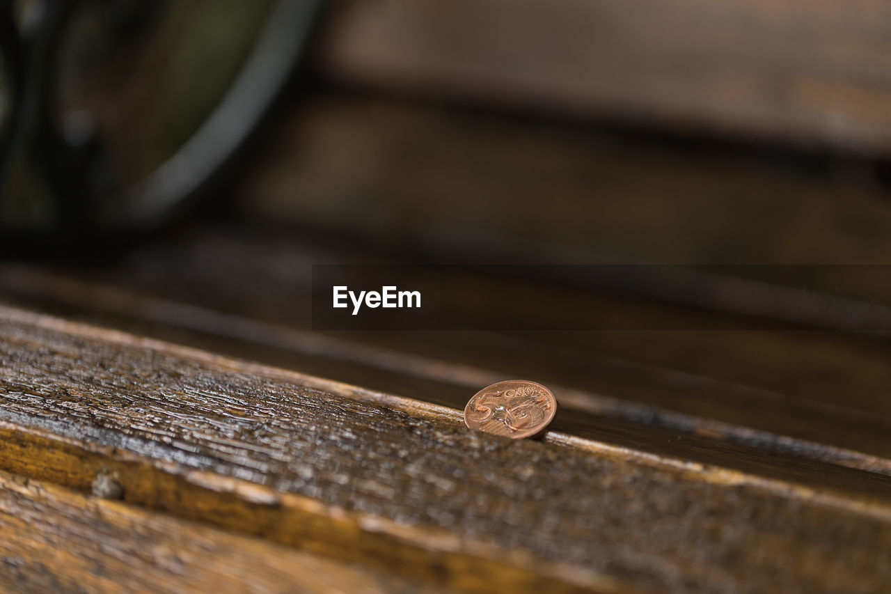 5 eurocent on a wooden bench at a rainy day.