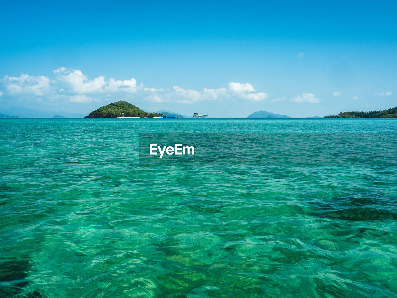 Scenic view of koh mak peaceful beach with crystal clear turquoise sea against blue sky. thailand.