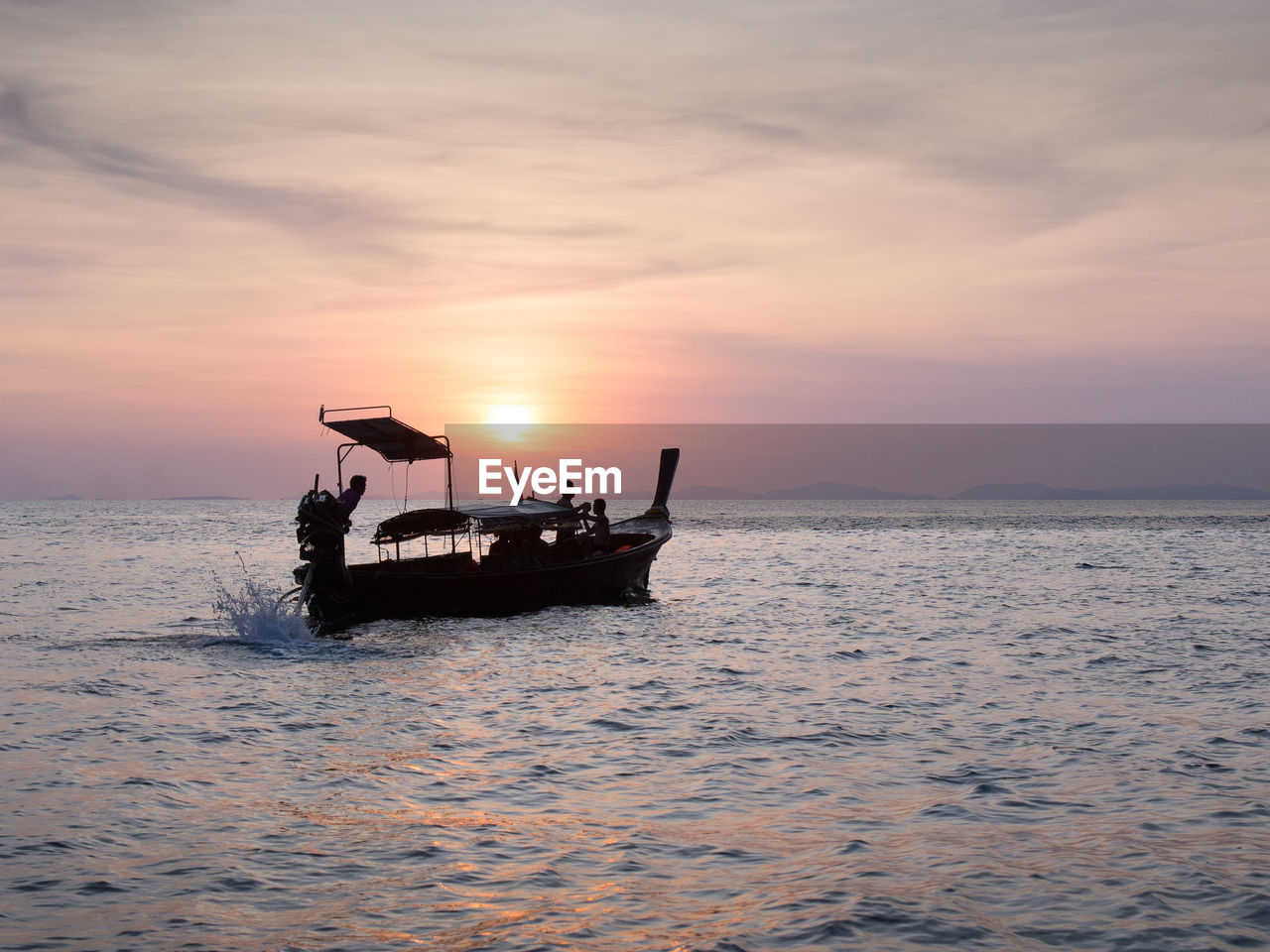 Scenic view of boat sailing in sea at sunset