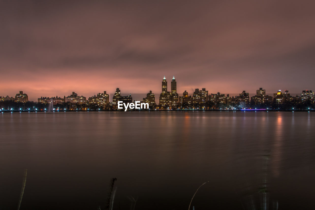 Illuminated cityscape against sky at night