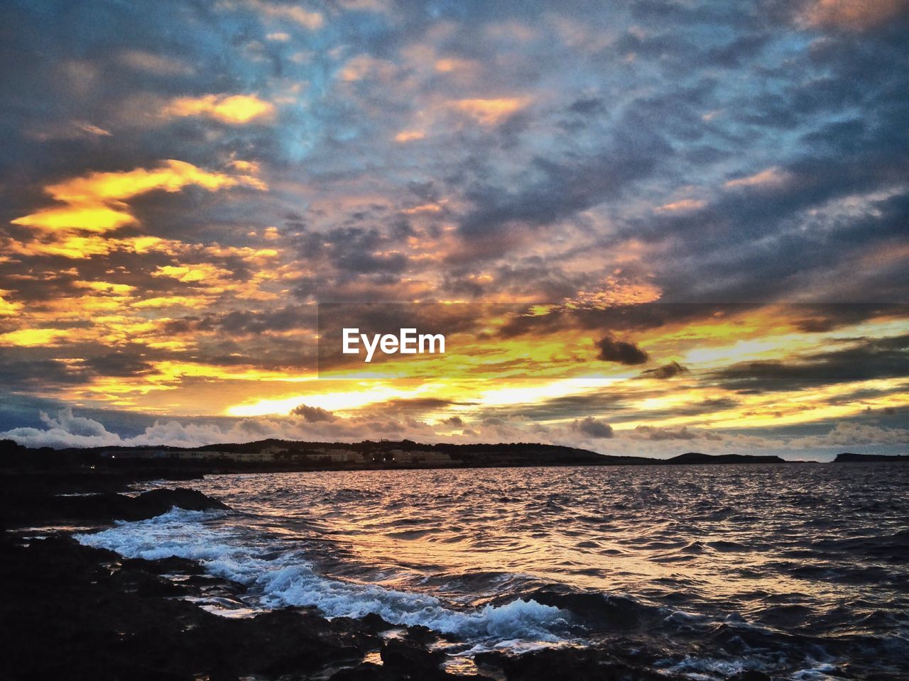 Scenic view of coastline at sunset