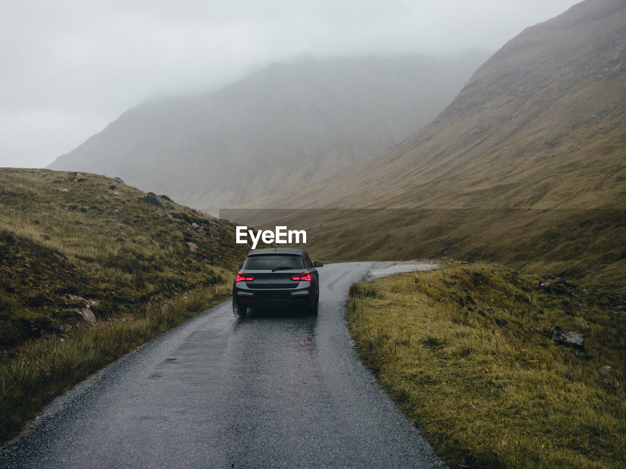 Car driving on road through glen etive