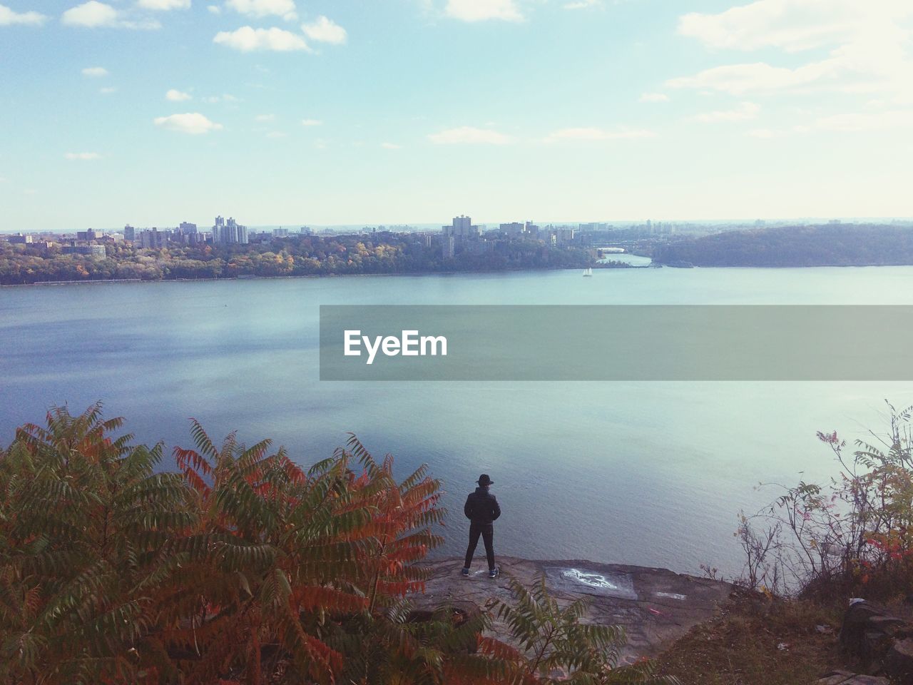 High angle view of man standing by river against cityscape