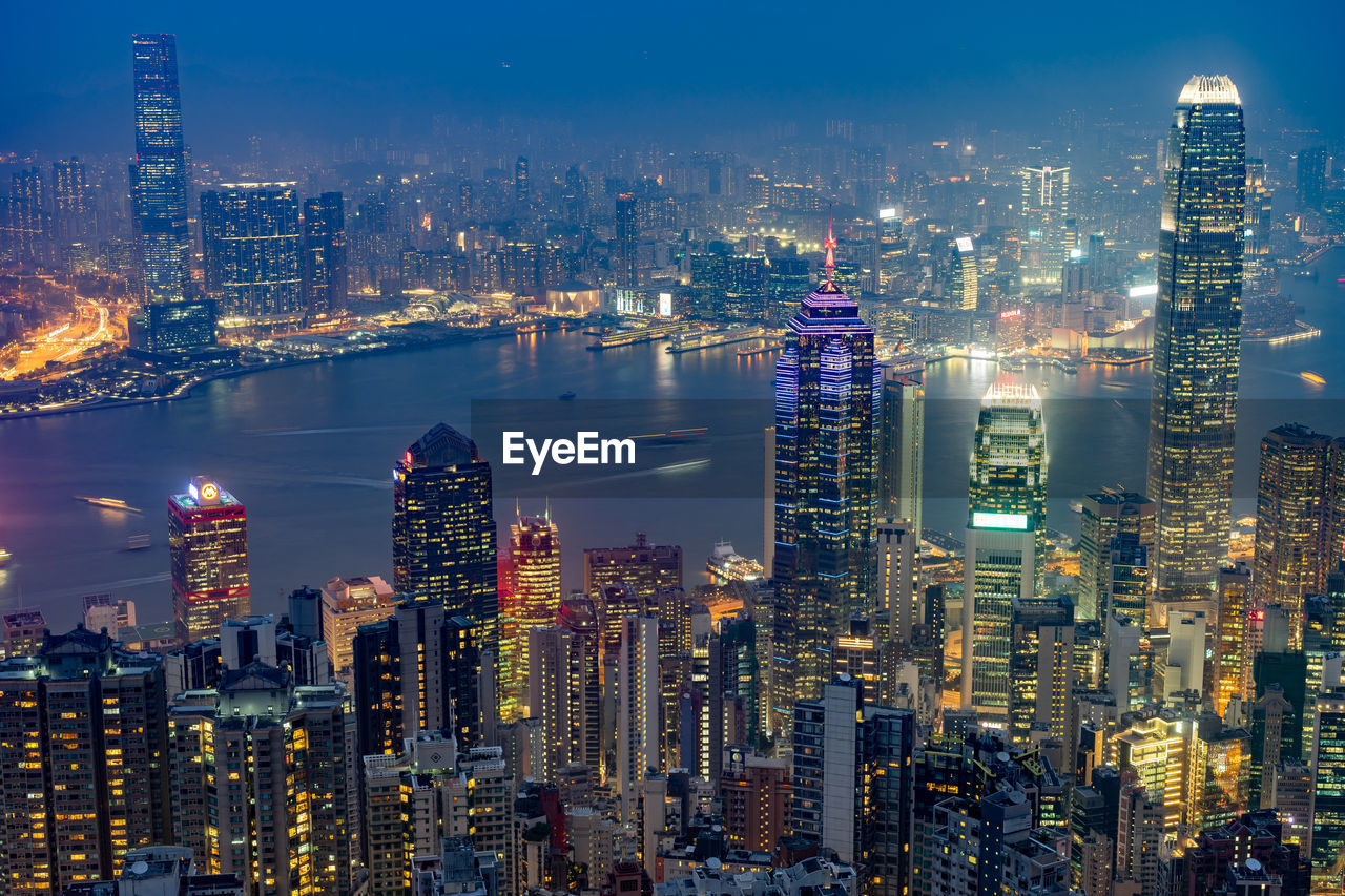 AERIAL VIEW OF ILLUMINATED BUILDINGS IN CITY AT NIGHT