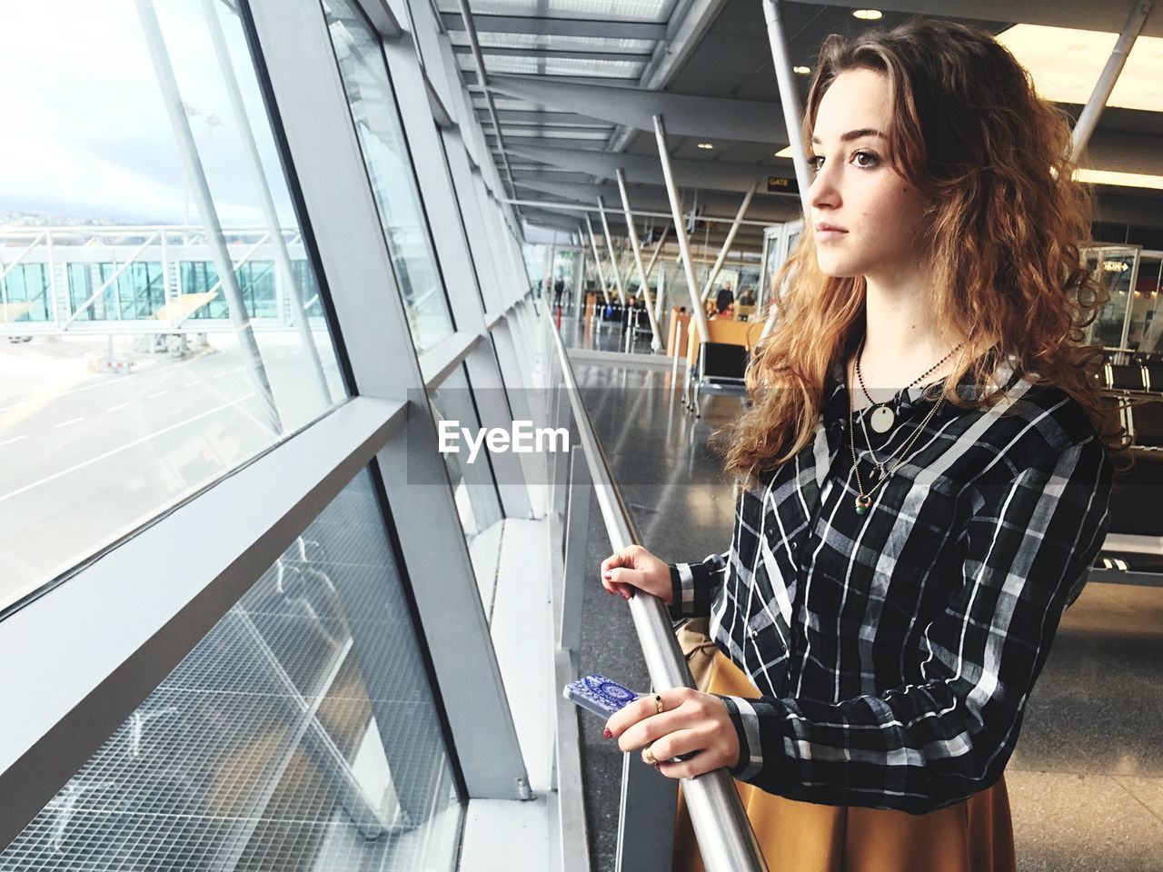 Thoughtful young woman standing airport terminal