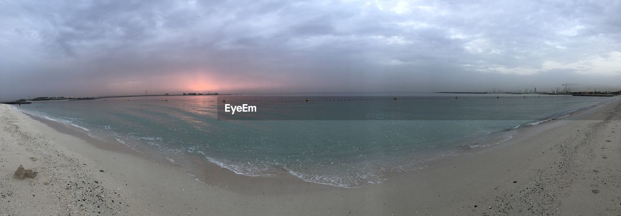 SCENIC VIEW OF BEACH AGAINST SKY AT SUNSET