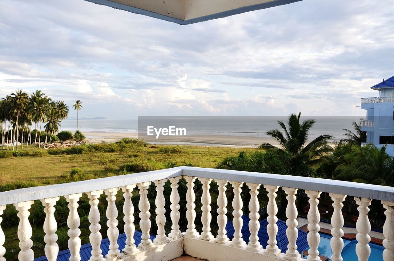 Balcony by sea against cloudy sky