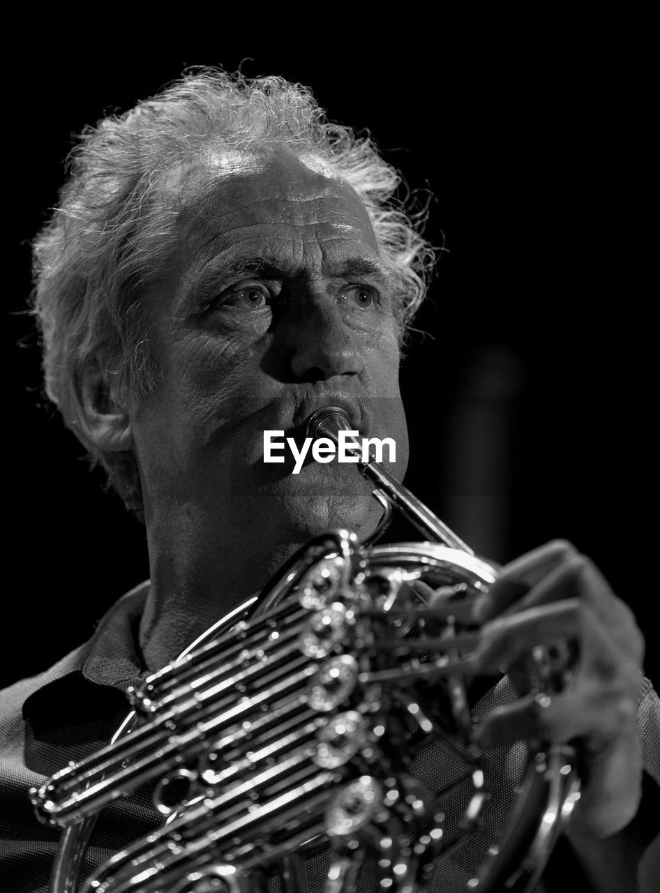 Close-up of man playing french horn