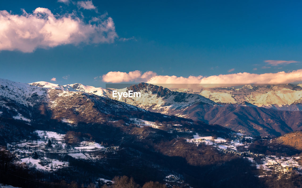 Scenic view of mountains against blue sky during winter