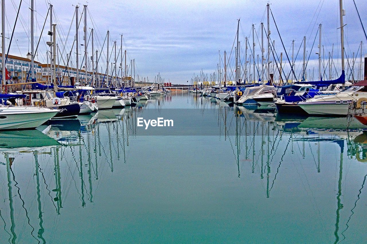 SAILBOATS MOORED IN HARBOR