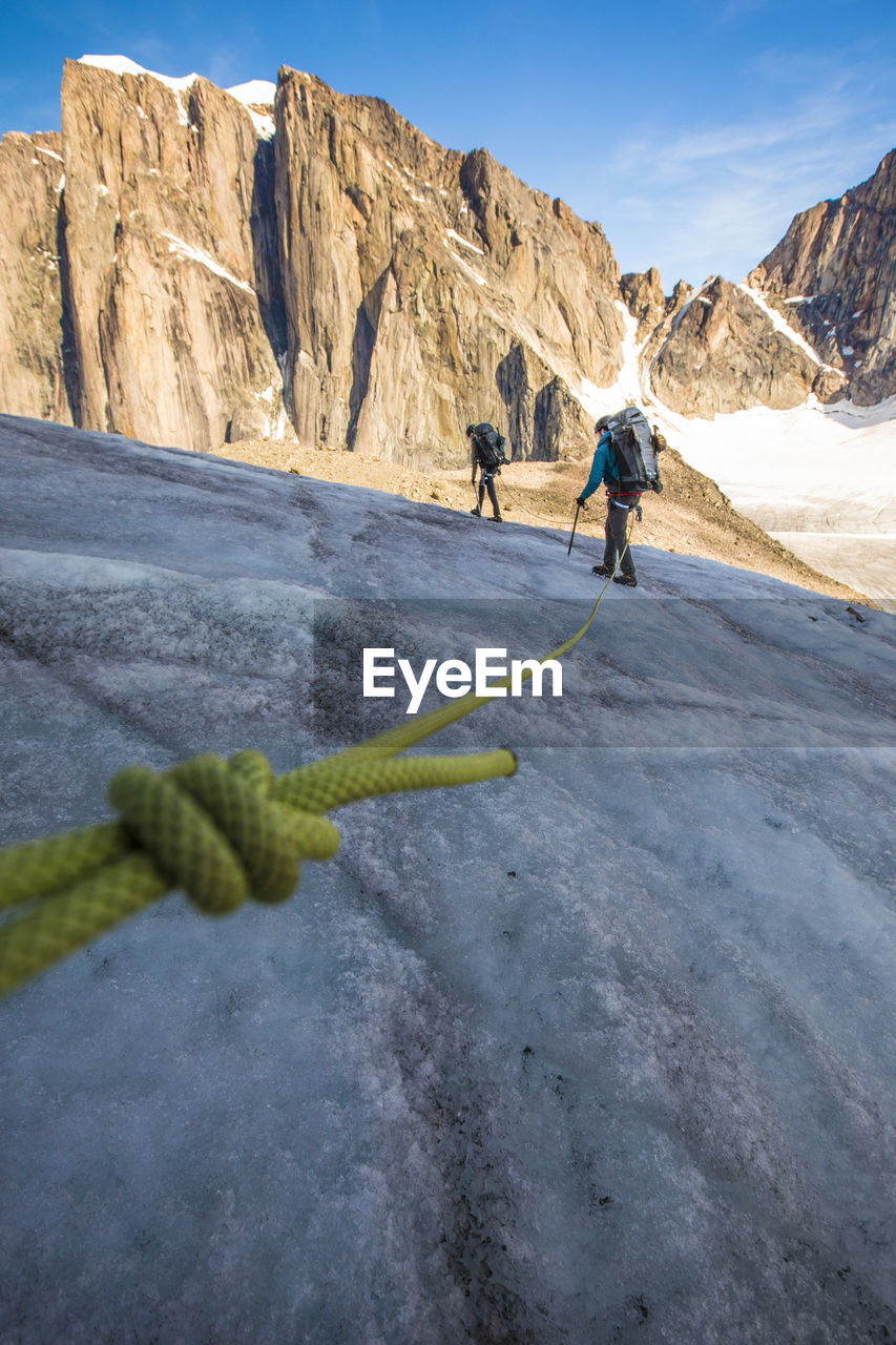 Roped mountaineering team crosses glacier high in the mountains.