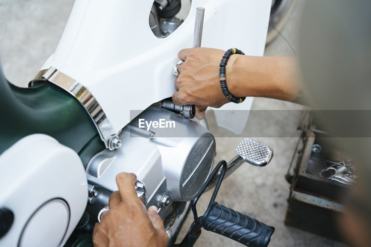 Cropped hand of mechanic working in garage