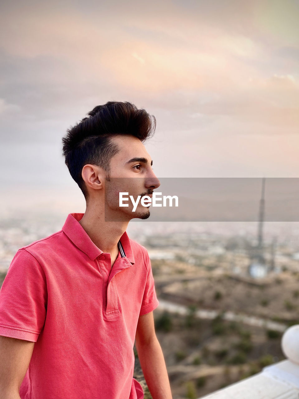 PORTRAIT OF MAN LOOKING AWAY AGAINST SKY