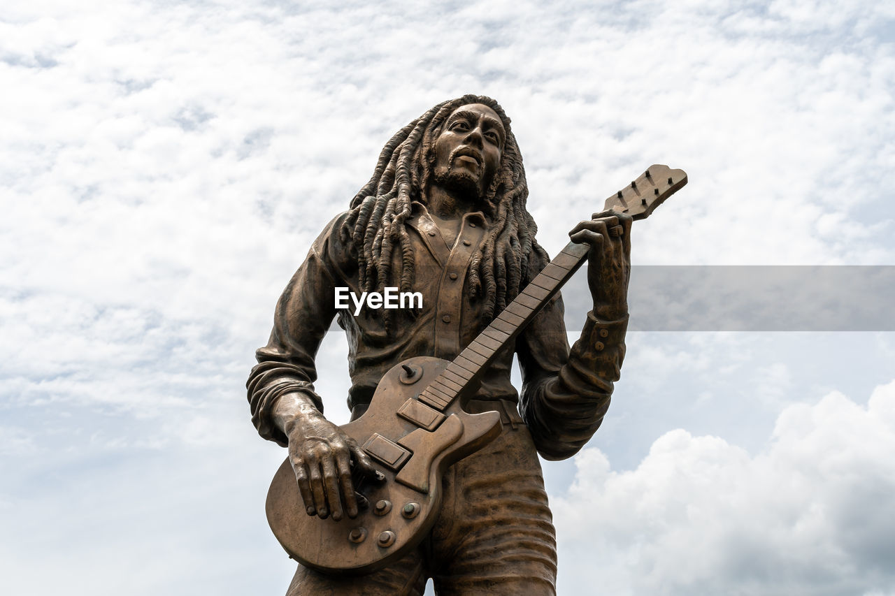 LOW ANGLE VIEW OF STATUE AGAINST SKY WITH CLOUDS