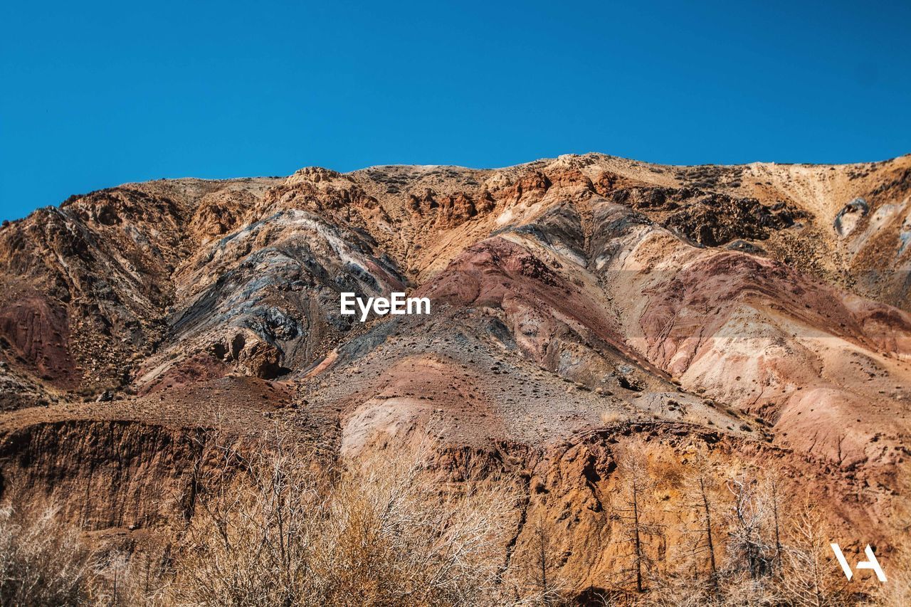 SCENIC VIEW OF MOUNTAIN AGAINST BLUE SKY