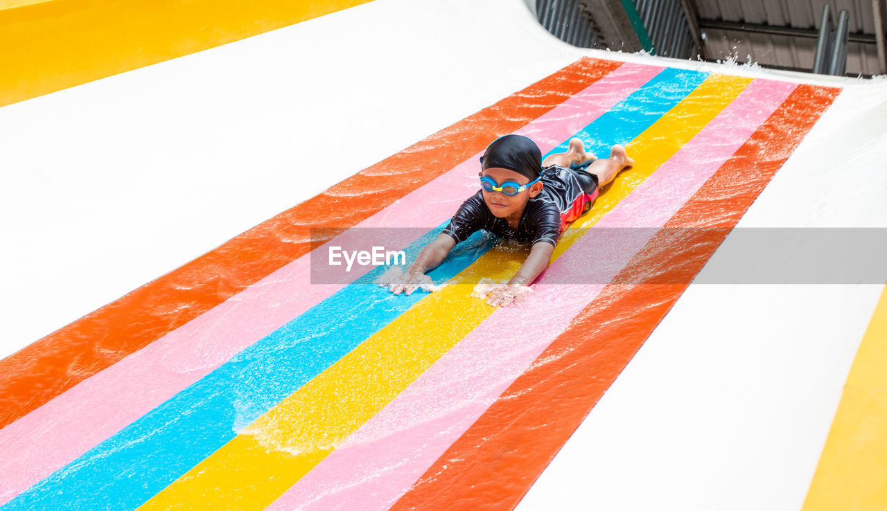 High angle view of boy on water slide in park