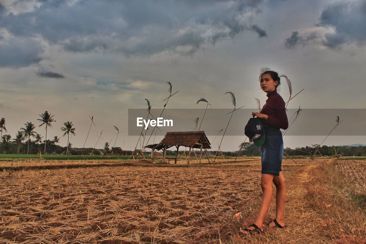 FULL LENGTH PORTRAIT OF BOY STANDING ON FIELD