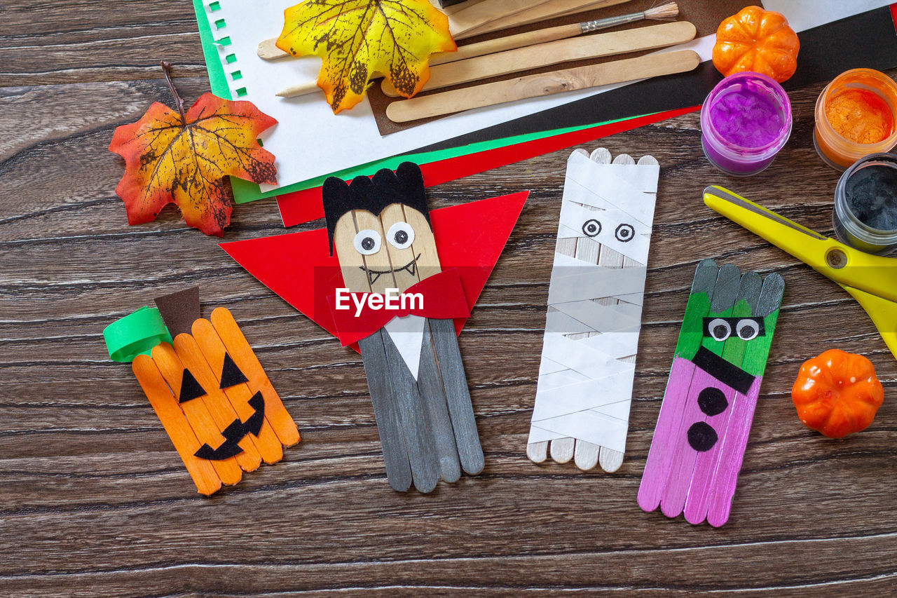 Halloween ghost, pumpkin, mummy and vampire toy gift stics puppets on wooden table. handmade. 