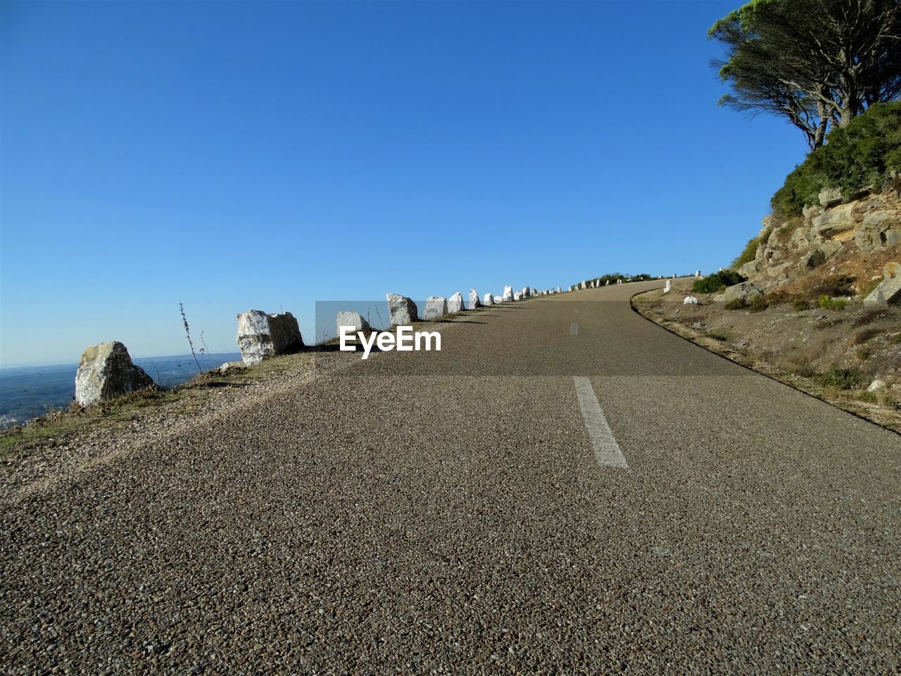 Road on beach against clear blue sky