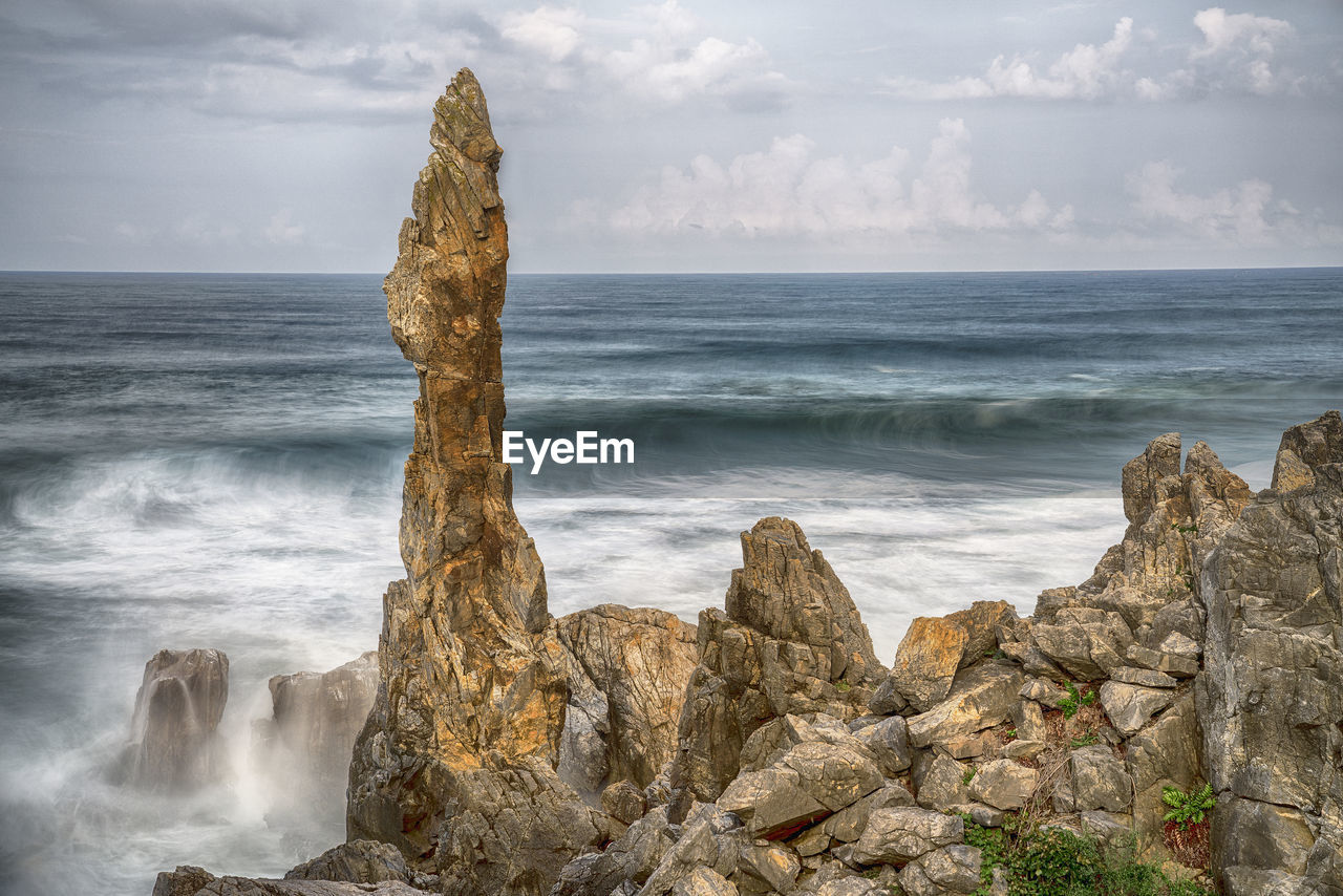 rock, sea, water, land, body of water, beach, shore, sky, beauty in nature, scenics - nature, coast, ocean, motion, wave, nature, cliff, cloud, horizon over water, horizon, environment, wind wave, terrain, no people, travel destinations, coastline, sports, water sports, outdoors, landscape, seascape, rock formation, tranquility, travel, idyllic, tranquil scene, long exposure, tower, sand