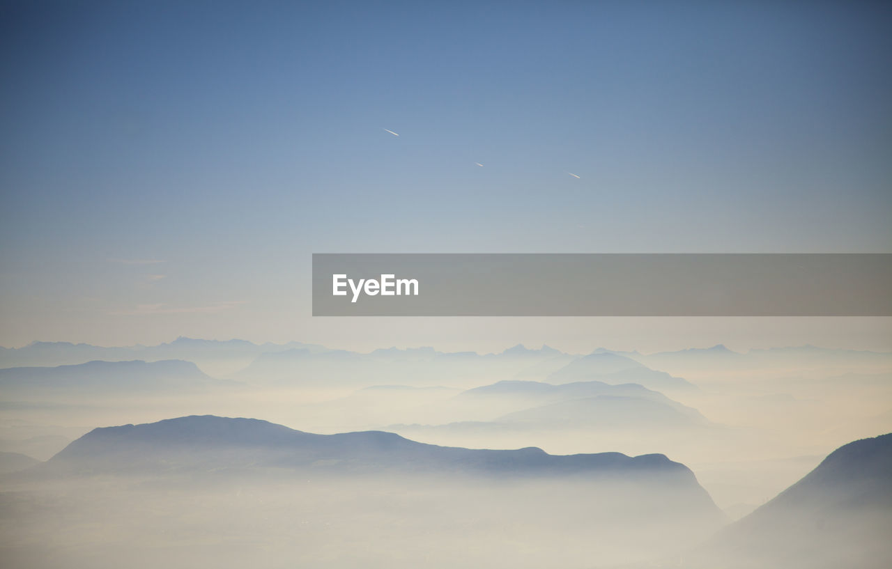 Scenic view of silhouette mountains against sky during foggy weather