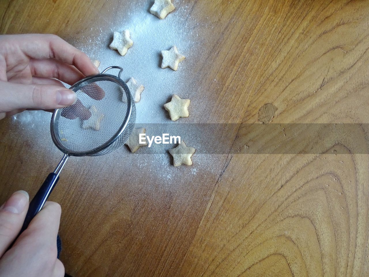 Cropped image of hands making cookies during christmas