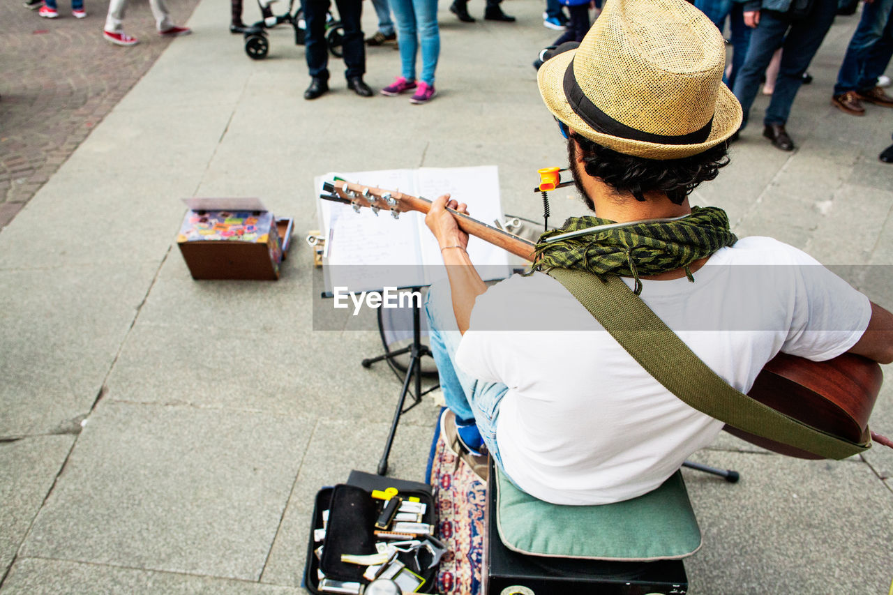 High angle view of street musician playing guitar