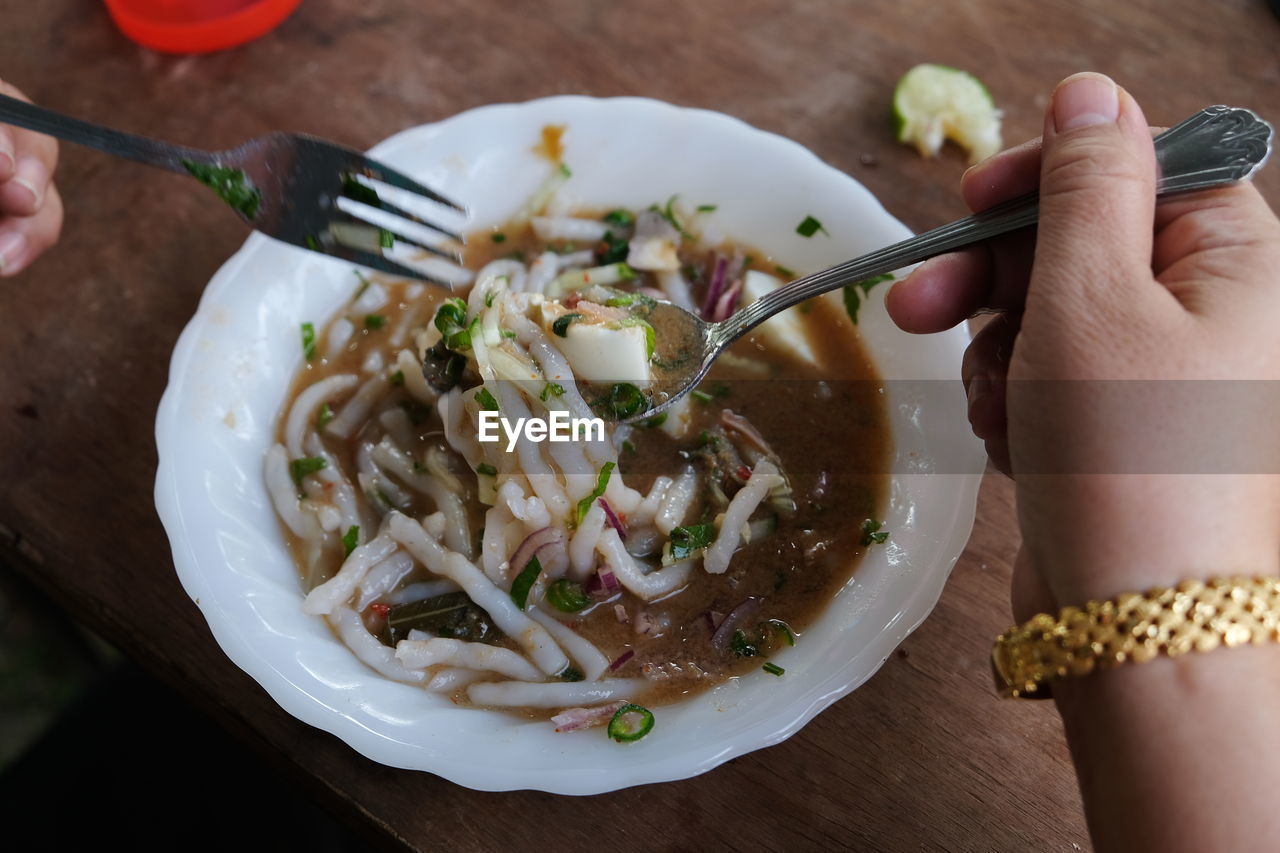 HIGH ANGLE VIEW OF HAND HOLDING FOOD