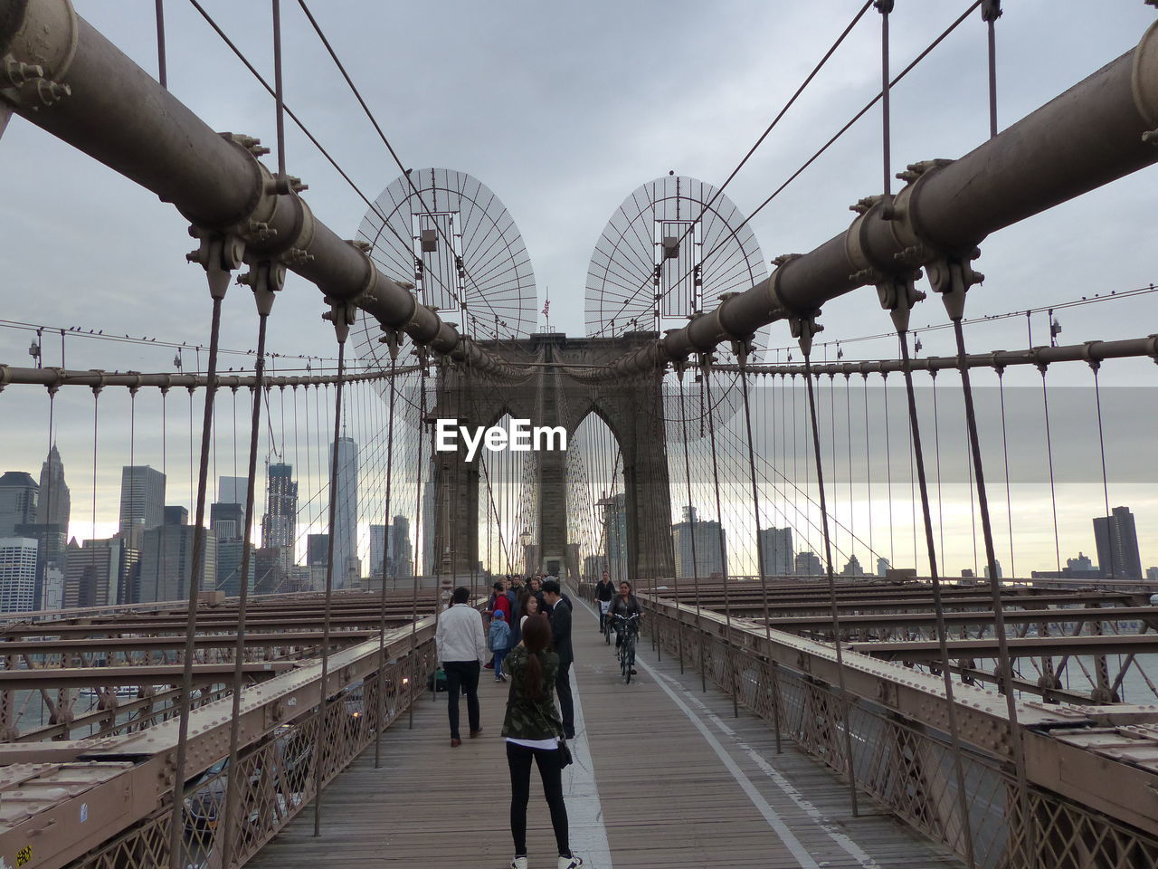 REAR VIEW OF PEOPLE WALKING IN SUSPENSION BRIDGE