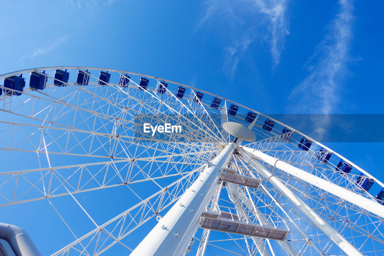 Low angle view of ferris wheel against blue sky