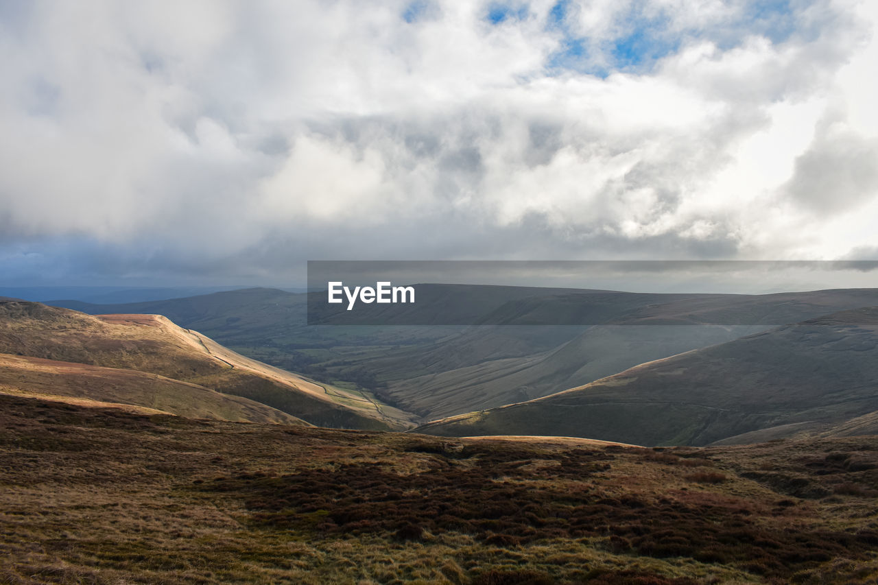 scenic view of mountains against cloudy sky