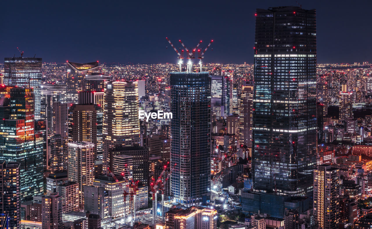 Illuminated cityscape against sky at night