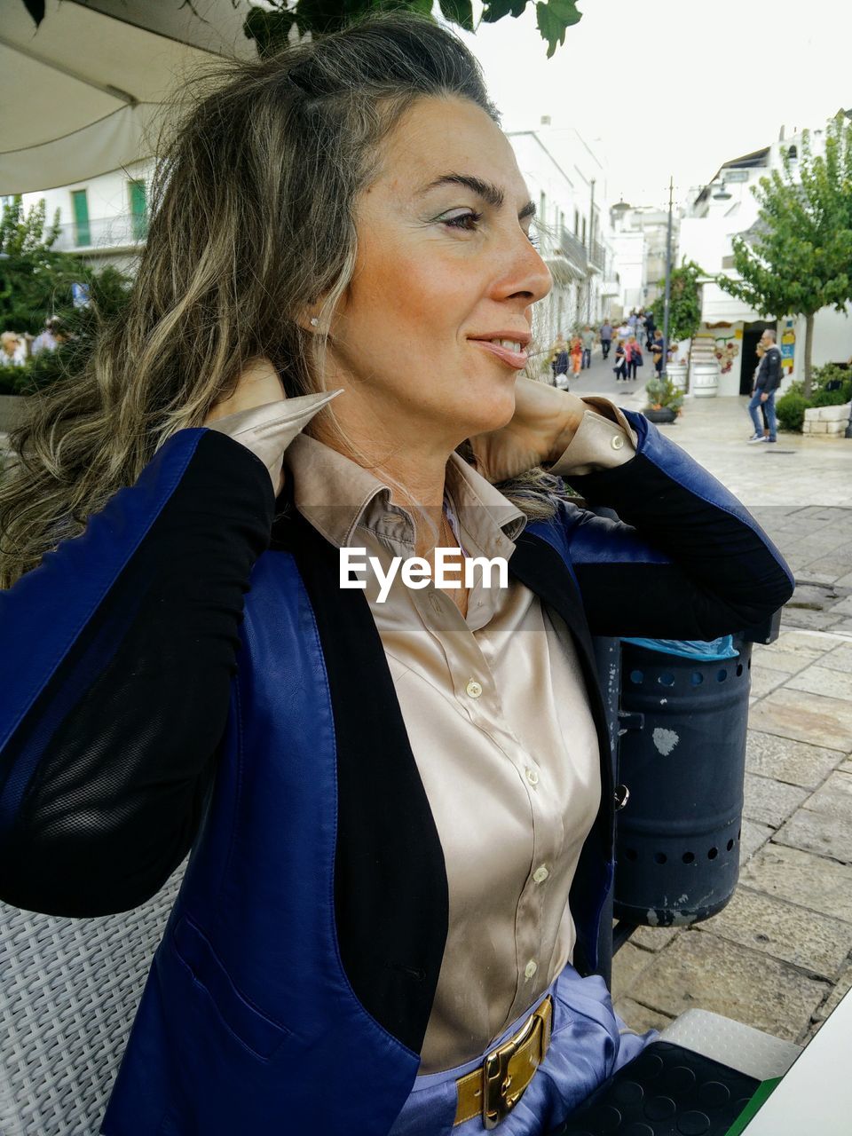 Mid adult woman looking away while sitting outdoors