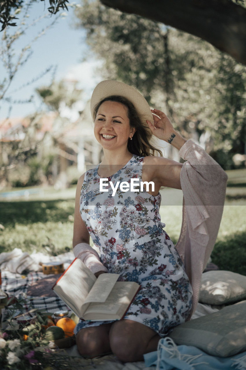 Smiling woman portrait outdoor, picnic with book