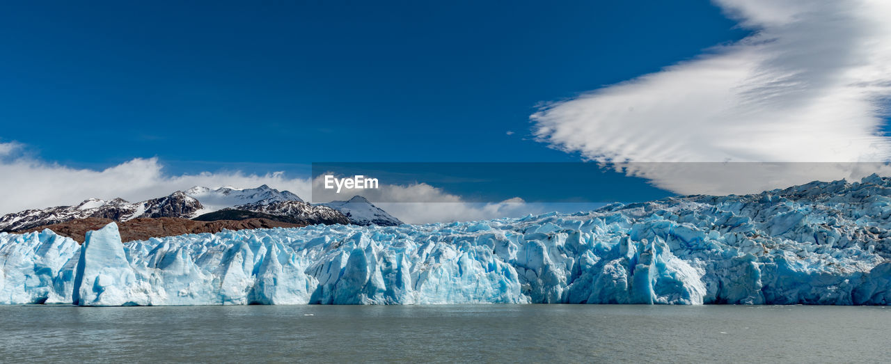 Panoramic view of sea and snowcapped mountains against sky