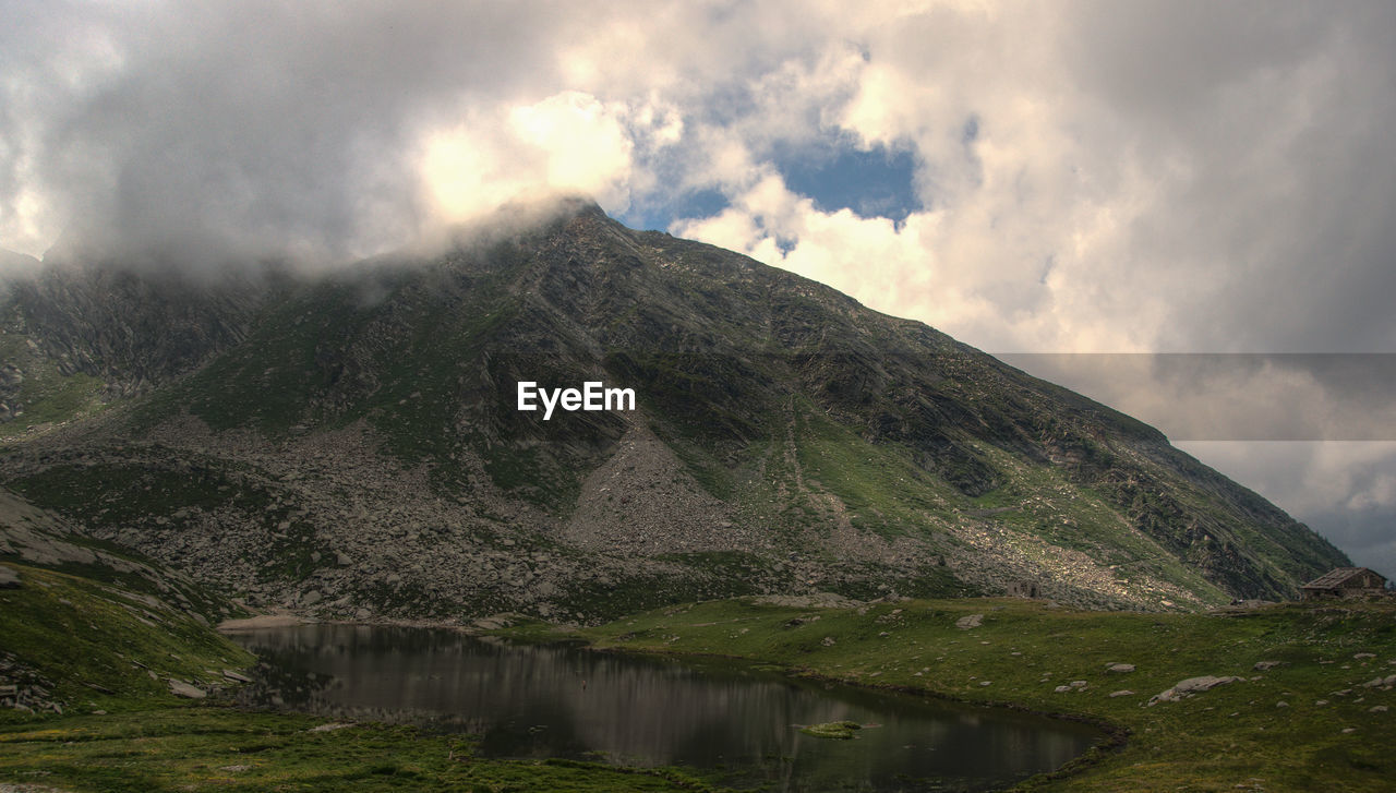 Scenic view of lake by mountains against sky