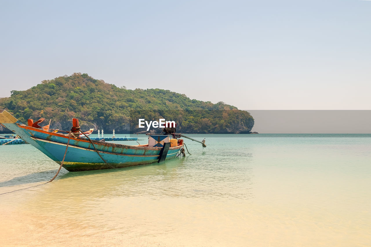 Boat moored on shore in sea