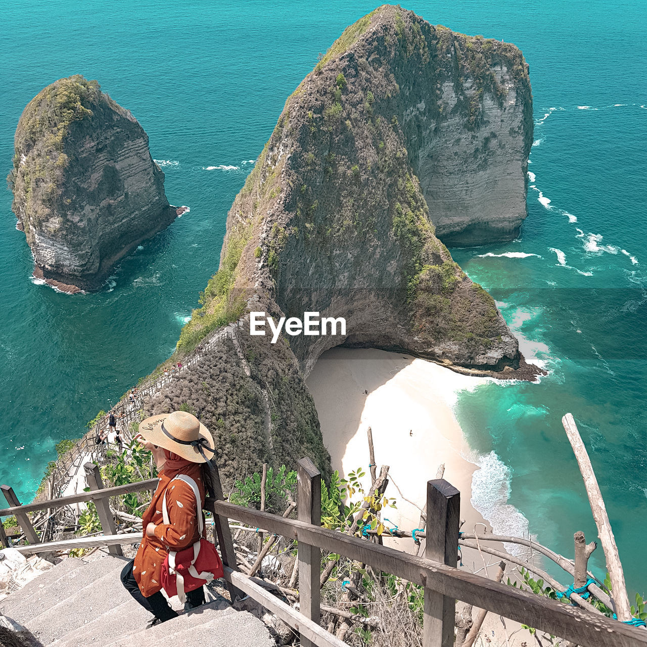 Woman sitting on rock by sea