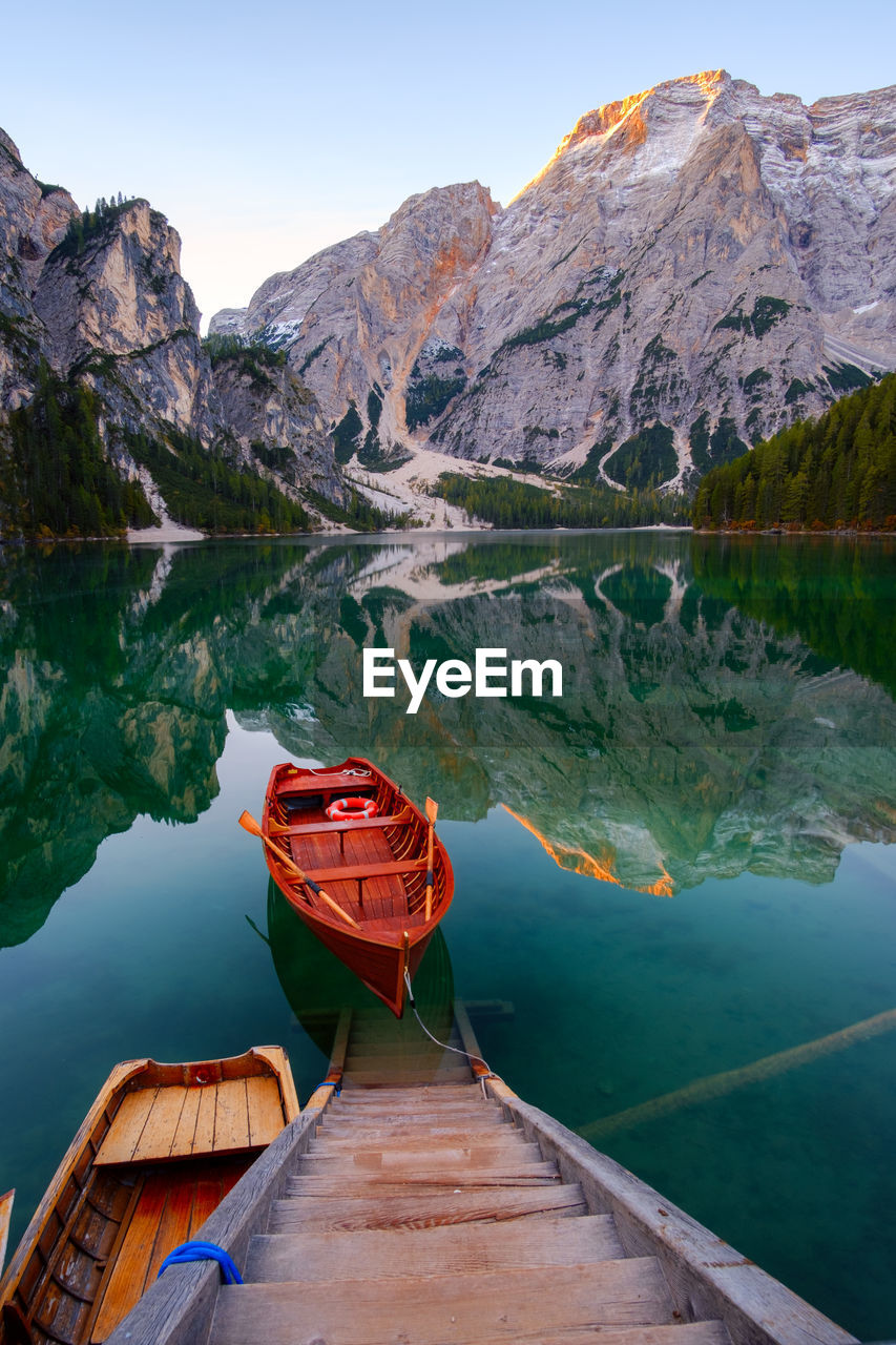 BOAT MOORED ON LAKE AGAINST SKY